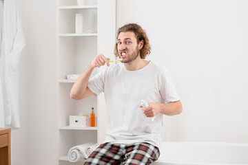 Poster - Handsome young man brushing teeth in bathroom