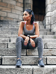 Wall Mural - Taking a break before the final challenge. Full length shot of an attractive young sportswoman sitting down on a stairway outdoors in the city.