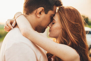 Side view portrait of a cheerful romantic couple posing standing closeness outdoors. Beautiful portrait. Close-up.