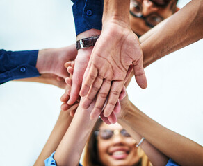 Wall Mural - Theyre ready to go. Low angle shot of a group of unrecognizable businesspeople joining their hands together in unity.