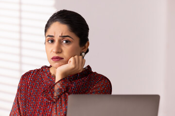 Wall Mural - Portrait of a sad woman employee with hand on cheek