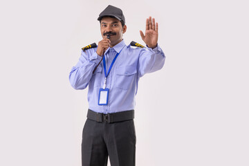 Wall Mural - Portrait of Security guard blowing whistle and gesturing with palm