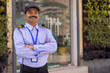 © IndiaPix - Portrait of security guard with arms folded while working at gate