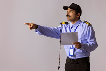 Wall Mural - Portrait of security guard pointing away with index finger
