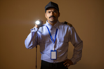Wall Mural - Security guard searching with torch light while working at night