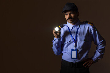 Wall Mural - Security guard searching with torch light while working at night