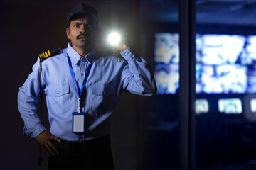 Wall Mural - Security guard searching with torch light while working at night