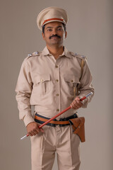 Wall Mural - Portrait of an Indian policeman standing with baton in hand