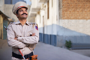 Wall Mural - Portrait of an Indian policeman looking elsewhere with arms folded