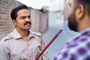 Wall Mural - Indian policeman threatening someone by raising baton