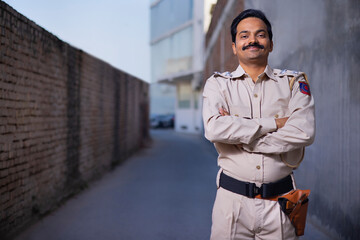 Wall Mural - Portrait of an Indian policeman standing with arms folded