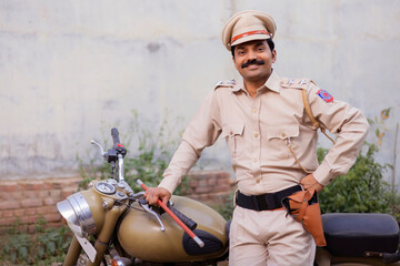 Wall Mural - Portrait of an Indian policeman posing with bike