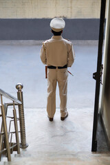 Wall Mural - Back view of an Indian Policeman standing at gate