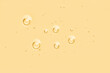 Yellow oil toner serum background. Skincare liquid surface with bubbles. Abstract cosmetic product macro