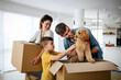 © NDABCREATIVITY - Husband and wife and their son with pet moving in new home.