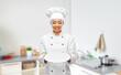 cooking, culinary and people concept - happy smiling female chef holding empty plate over kitchen background