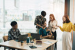 © Natee Meepian - group of young creative asian people doing brainstorming meeting colleagues in board room discussing project. woman standing at white board give presentation