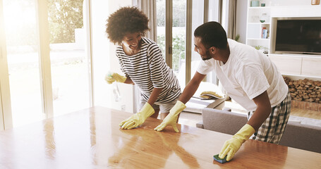 Aufkleber - We make a great team. Shot of a cheerful young couple cleaning the surface of a table with cleaning equipment together at home.