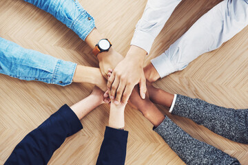 Poster - Its easier if we do it together. High angle shot of a group of unidentifiable businesspeople joining their hands together in unity.