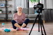 © Syda Productions - fitness, sport and video blogging concept - happy senior woman or blogger with camera streaming online class at home