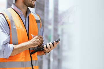 A portrait of an industrial man engineer with smartphone in a factory, working.