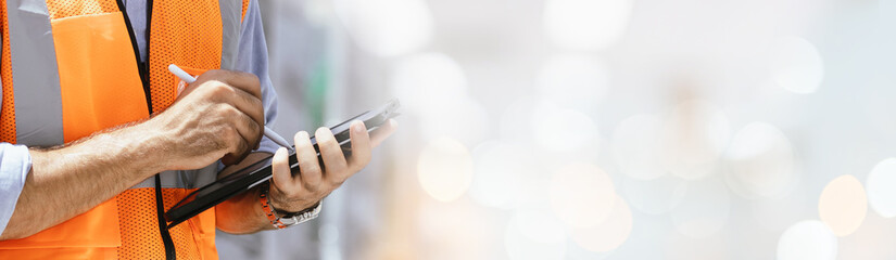 A portrait of an industrial man engineer selective focus with smartphone in a factory, working banner