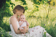 Beautiful Mother And Baby On Nature. Young Woman With Her Baby In Harmony. Concept Of Natural Motherhood, Human Happiness, Healthy Family, Eco Sustainable Lifestyle. Loving Mom With Child Outdoors.