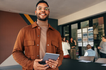 Wall Mural - Happy businessman looking at the camera in a boardroom