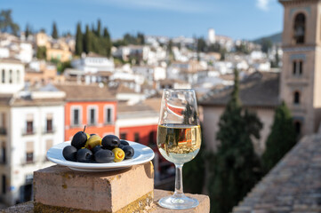 Tasting of Spanish sweet and dry fortified Vino de Jerez sherry wine and olives with view on roofs and houses of old andalusian town