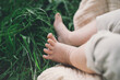 © nataliaderiabina - Baby tiny cute feet in green grass outdoors. Baby lying on blanket at summer on nature.