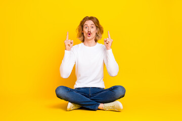 Poster - Photo of attractive impressed guy wear white shirt pointing fingers up empty space isolated yellow color background