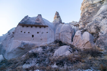 Wall Mural - Fairy tale chimneys in Cappadocia with blue sky on background in Goreme,Nevsehir, Turkey. Volcanic rock landscape, Stone houses. 