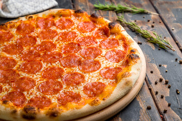 Poster - Pepperoni pizza on old wooden table macro close up