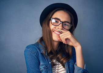 Wall Mural - Ive got a finger full of fun. Shot of a comical young woman posing with a mustache drawn on her finger in studio.