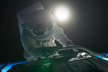 Wall Mural - female astronaut performing spacewalk, working on a outer part of a space craft