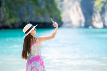 Female tourist walking to check signal 5G mobile phones on tropical islands, Koh Lipe, Andaman Sea, Thailand