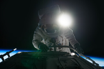 Wall Mural - female astronaut performing spacewalk, working on a outer part of a space craft