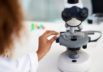  Time to inspect this sample. Cropped shot of a young female scientist analysing a sample in the lab.