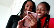 © Marco - Mixed race teen girls using smartphone device. Black African teenagers smiling and laughing