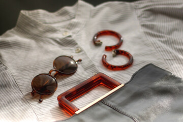 Wall Mural - Striped shirt, leather bag, brown sunglasses and tortoiseshell pattern sunglasses. Selective focus.