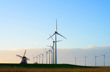 Netherlands, Eemshaven, Wind Turbines And Windmill In Field