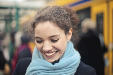 smiling young woman outside a train station