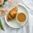 Romantic morning cup of coffee with a croissant on a bed,top view.