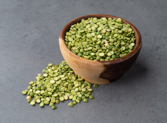 Raw dried green peas in a bowl over stone background