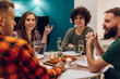 © Zamrznuti tonovi - Group of friends enjoying dinner while sitting at the kitchen table together