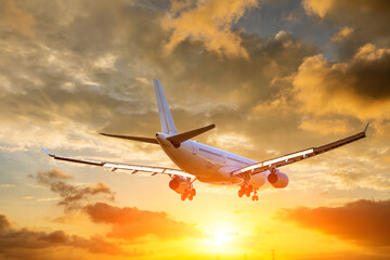 Wall Mural - Airplane in the sunset sky. travel concept.