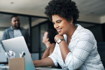 Todays a good business day. Shot of a young woman using a laptop in an office.