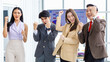 © Bangkok Click Studio - Group of young happy male and female professional successful businessman and businesswoman colleagues partnership in formal business suit standing rise fists up smiling celebrating job done together