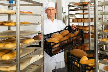 Wall Mural - Portrait of baker with fresh bread at the bakery