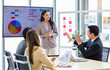 © Bangkok Click Studio - Asian professional successful businessman and businesswoman employee in formal suit standing at working desk in meeting room discussing brainstorming together about company growth target and margin